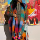 A multicolored plaid wool kimono displayed on a mannequin with pom-pom details at the ends.