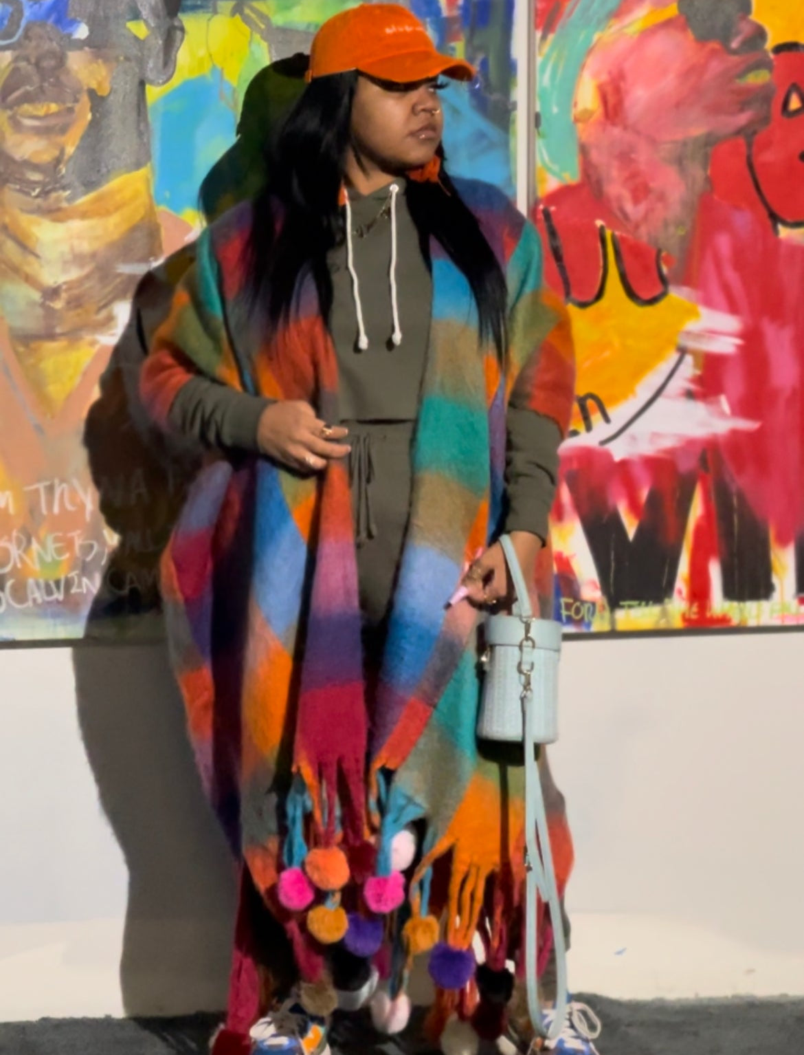 A multicolored plaid wool kimono displayed on a mannequin with pom-pom details at the ends.