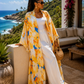 Woman in a yellow floral kimono standing on a balcony with ocean view