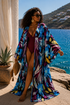 flowy floral kimono cover-up over a deep burgundy one-piece swimsuit. The cover-up has a bold tropical floral pattern in blue, purple, yellow, and white.