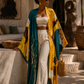 Woman in a yellow and blue kimono standing on stone steps in an outdoor setting. (Teal)