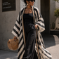 Woman wearing a black and white striped kimono over a black outfit, standing outdoors. (Black)