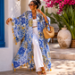 blue patterned linen kimono standing outdoors with plants and a blue door in the background