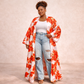 Ember Petals Kimono Woman wearing a floral kimono over a white top and ripped jeans on a beige background