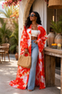 Woman wearing a red and white floral kimono with blue jeans, standing outdoors.