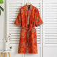 Orange floral kimono hanging on a white wooden panel background (Red)