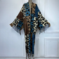 Leopard print scarf with fringes draped over a mannequin against a white paneled wall. (Blue)