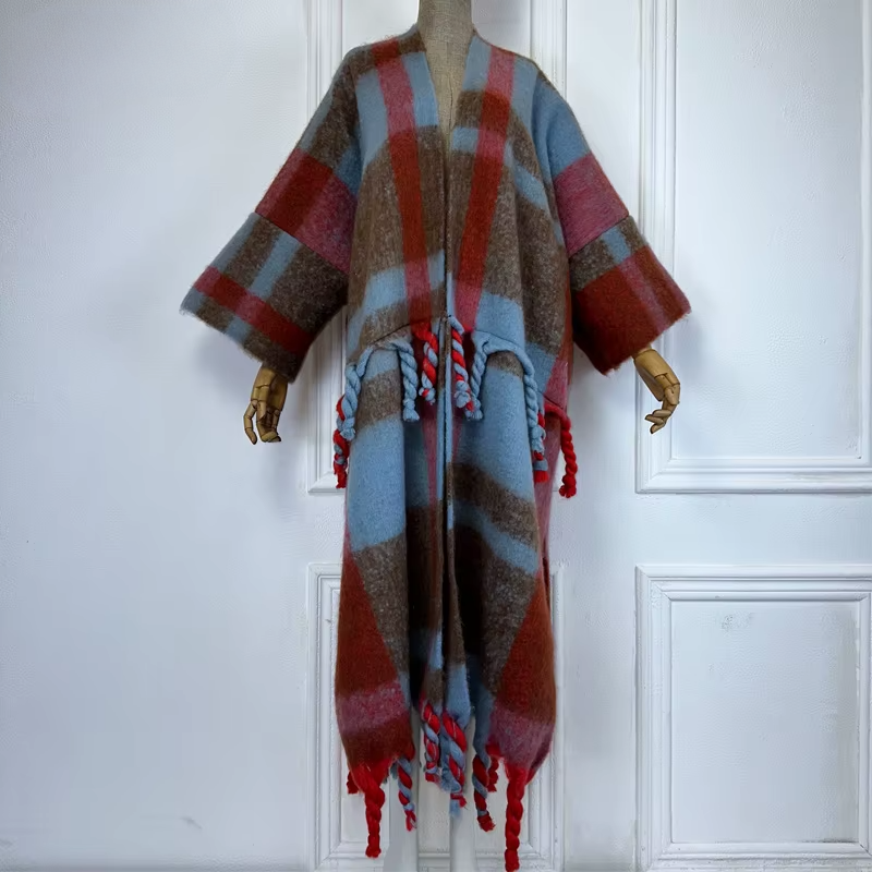 A model wearing a long, plaid wool kimono in green and black with fringed edges. (Blue)