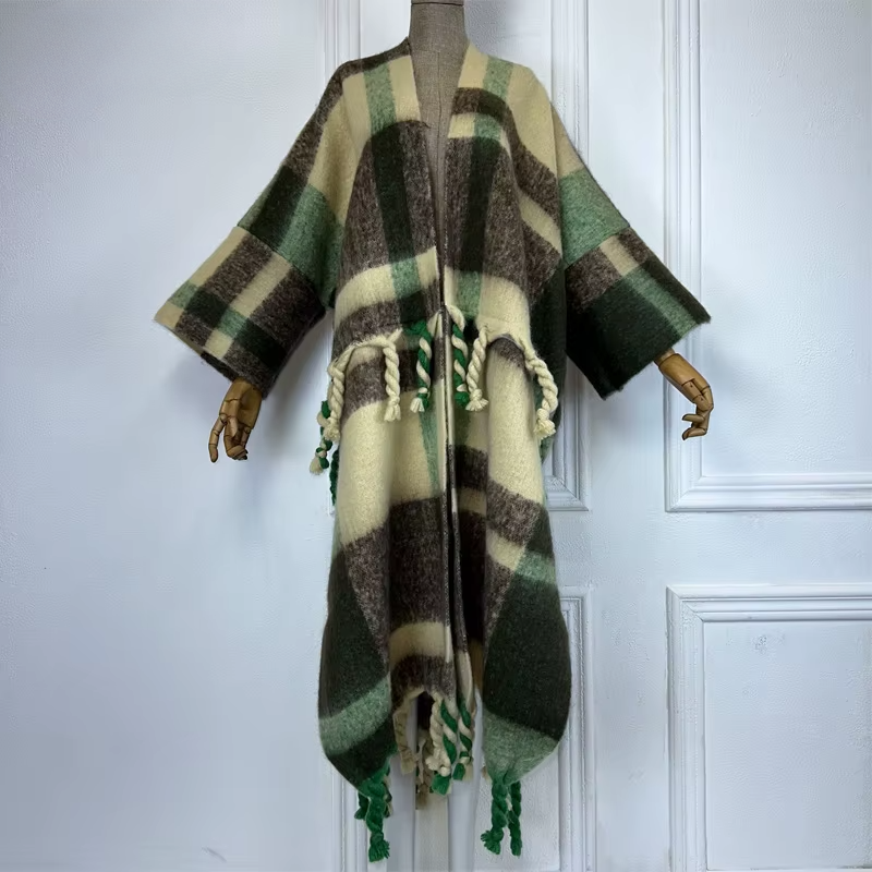 A model wearing a long, plaid wool kimono in green and black with fringed edges. (Green)