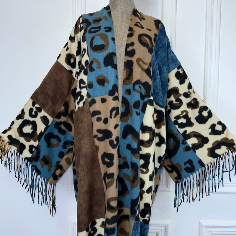 Leopard print shawl with fringes draped over a mannequin against a white wall. (Blue)