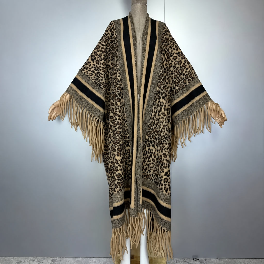 A leopard print open-front poncho cardigan with fringe trim, displayed on a mannequin against a light gray background. (Brown)