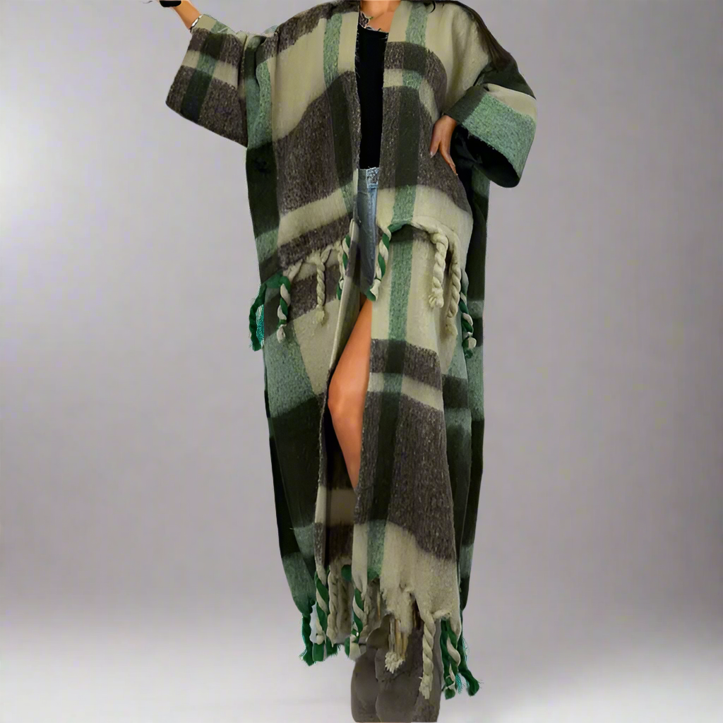 A model wearing a long, plaid wool kimono in green and black with fringed edges. (Green)