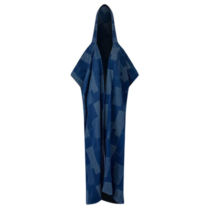 A hooded denim kimono with a geometric patchwork design in shades of blue and indigo, displayed in an open and draped position. (Light Blue)