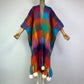 Colorful striped poncho with tassels on a mannequin against a plain background