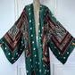 Colorful patterned kimono draped over a mannequin against a white wall. (Green)